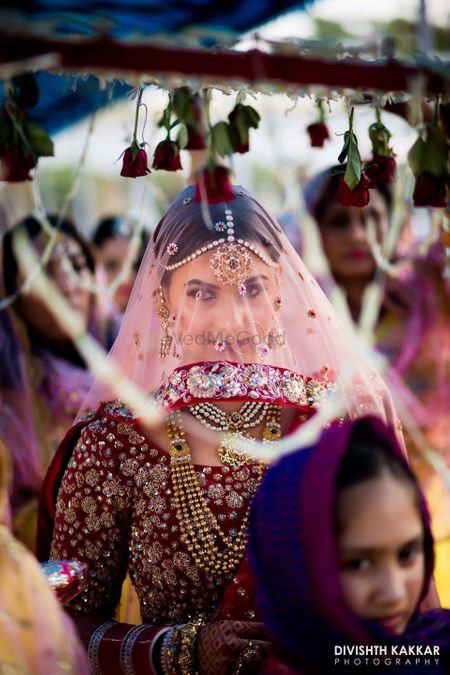 Bride entering wearing dupatta as veil