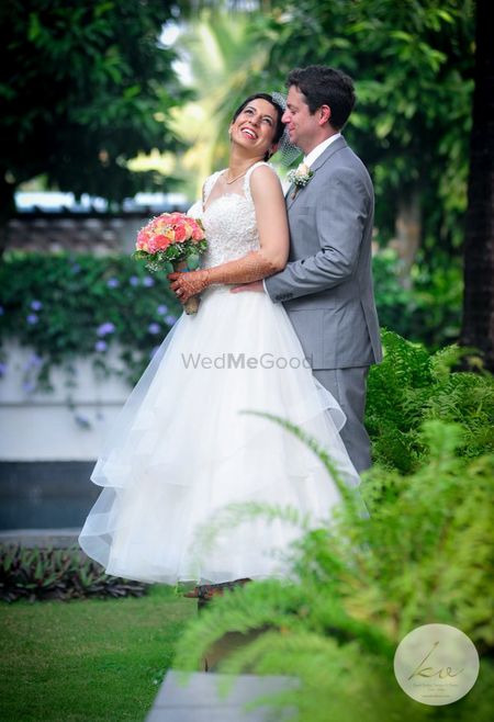 Photo of A Christian couple poses with a bouquet