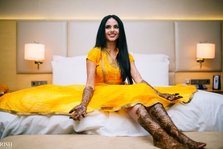 Bride to be sitting with flared anarkali on mehendi day