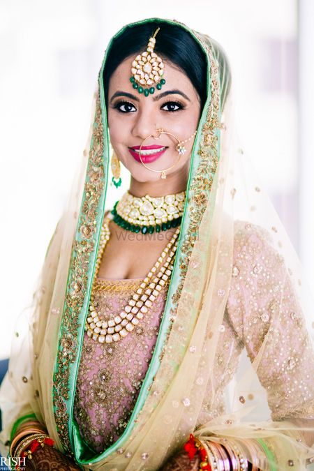 Pastel bride wearing contrasting jewellery with green beads