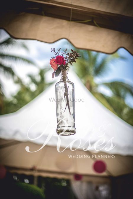Hanging glass bottle with flowers in decor
