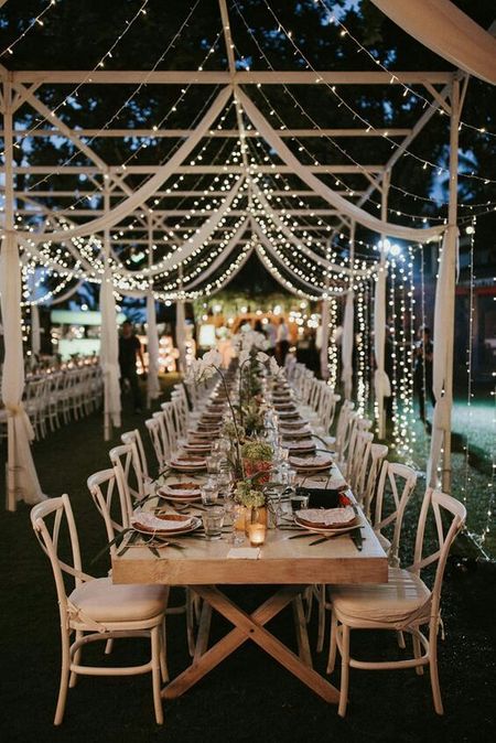 Photo of Long table setting for intimate event with fairy lights