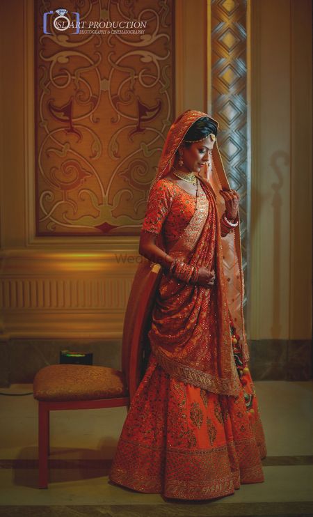 Photo of Gorgeous bridal lehenga in orange and gold