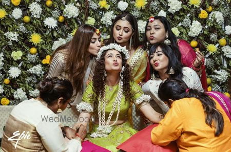 Bride getting mehendi put with bridesmaids 