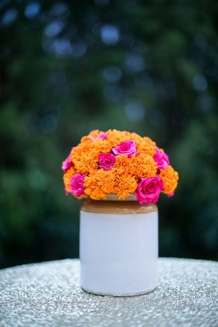 Cute marigold and rose centrepiece in pickle jar