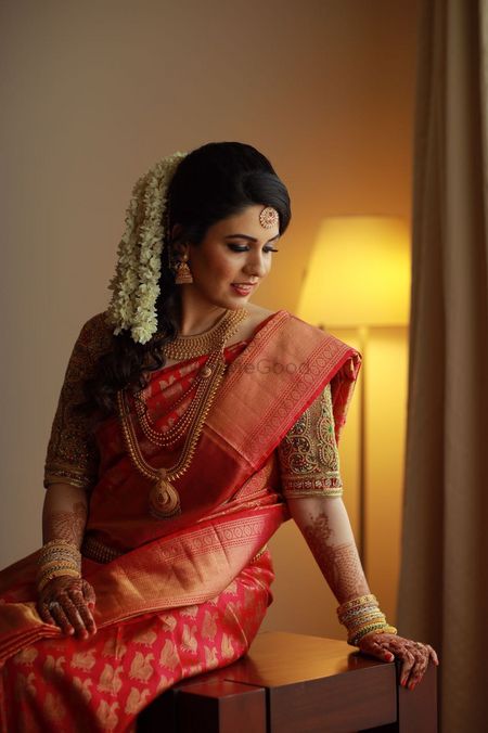 South Indian bride in red saree with gajra in hair