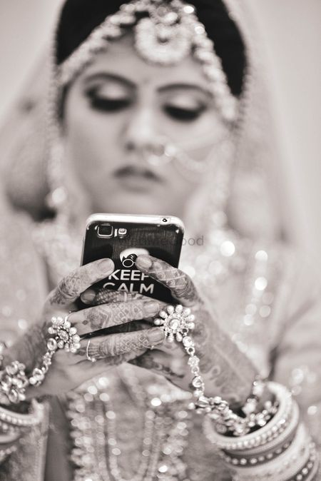 black and white bridal shot with bride on her phone 