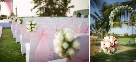 Photo of white chairs with light pink bow and white flower bunch