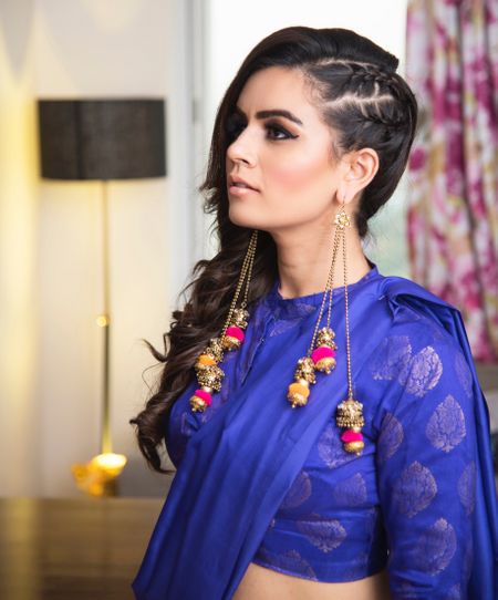 Funky hairstyle and earrings for sister of the bride on mehendi