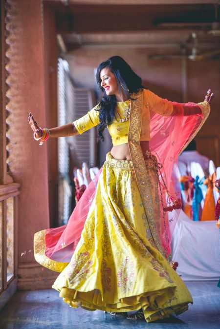 Happy dancing bride in yellow lehenga