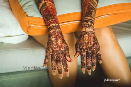 Mehendi with portraits of bride and groom on back of hands