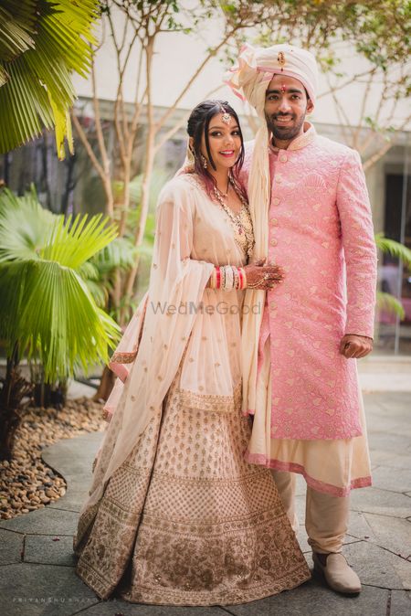 Bride and groom in matching light pink outfits