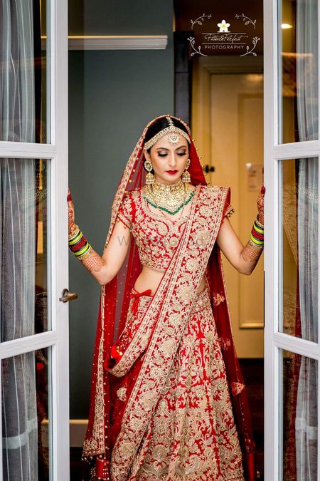 Photo of Conventional red bride wearing green jewellery