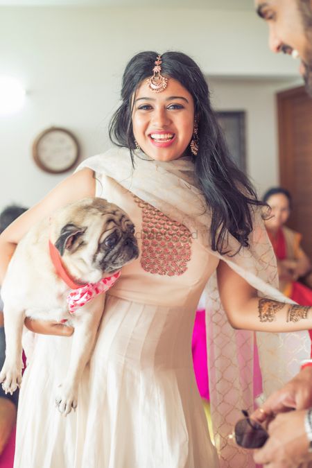 Photo of Bride with pet pug on mehendi