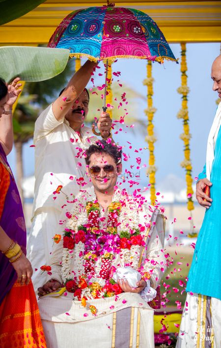 Groom entry with falling petals and umbrella