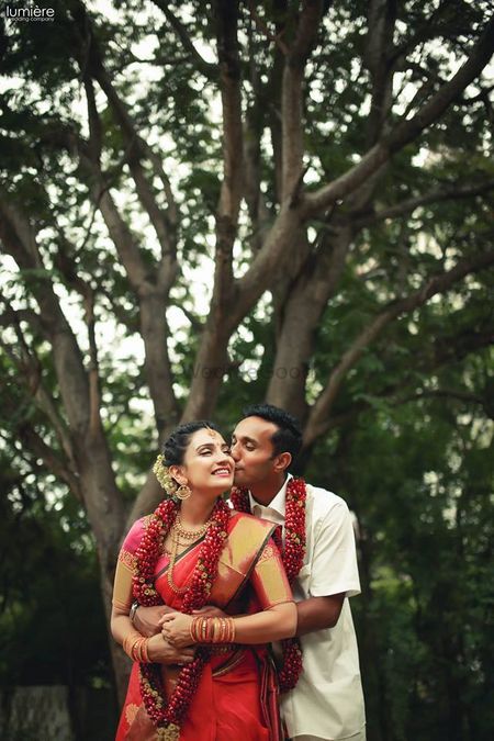 Cute groom kissing bride South Indian wedding shot