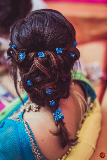 Mehendi hairstyle braid with tiny blue flowers