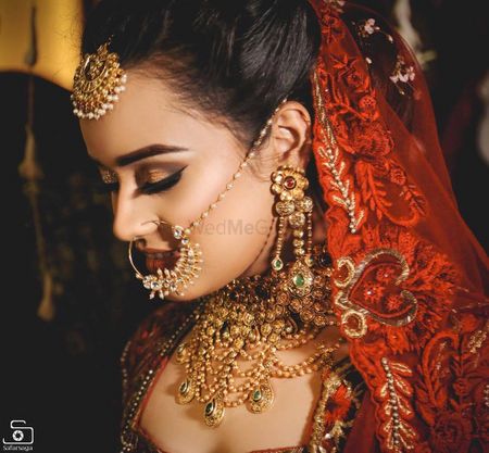 Photo of Unique gold choker with bridal nath and maangtikka