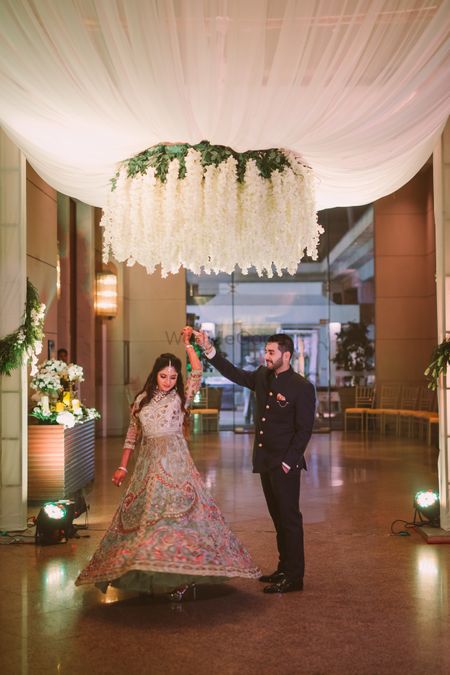 Couple dancing under floral chandelier