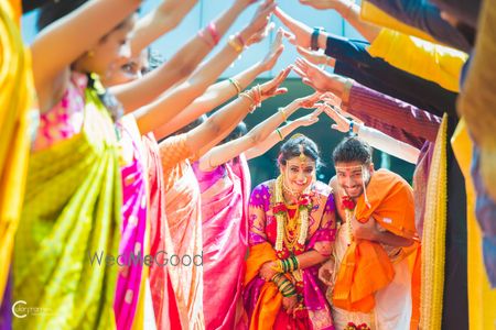 Everyone holding up hands as couple enters