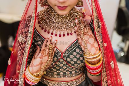 Photo of Red and black bridal lehenga with gold and red jewellery