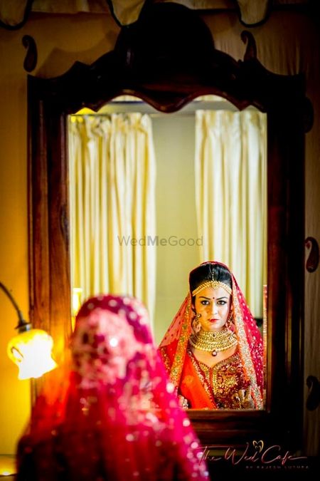 Photo of Bride getting ready looking in mirror shot