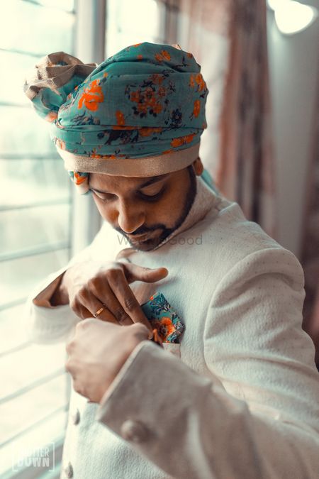 Contrasting groom accessories with white sherwani 