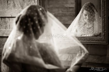 Photo of Black and white bridal portrait bride looking into mirror