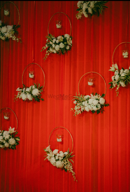 Red backdrop with floral wreaths and candles