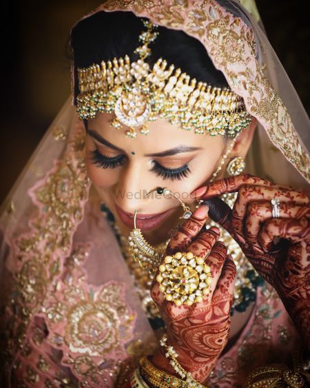 Photo of A beautiful bride with gold makeup and gold jewellery.