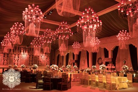 Multiple chandeliers for a wedding function lit by candles