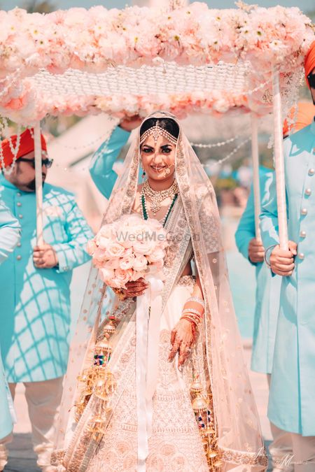 Gorgeous bridal entry shot with unique peach phoolon ka chadar 