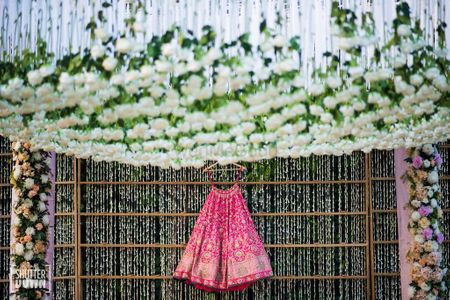 Bright pink bridal benarasi lehenga on hanger 