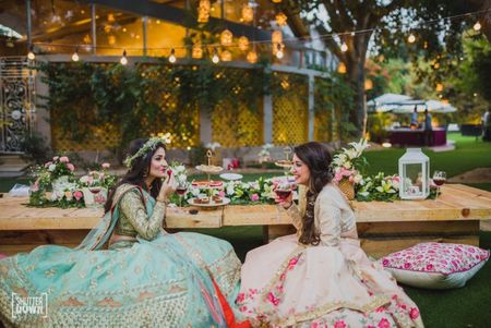 Bride with sister in lehengas during backyard engagement