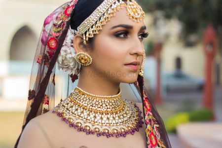Bride wearing bib necklace and round earrings 