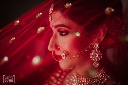 Bridal portrait with red dupatta as veil 