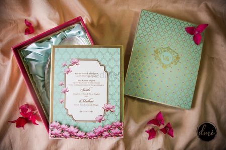 Unique mint green and pink lotus motif wedding invitation card in a box