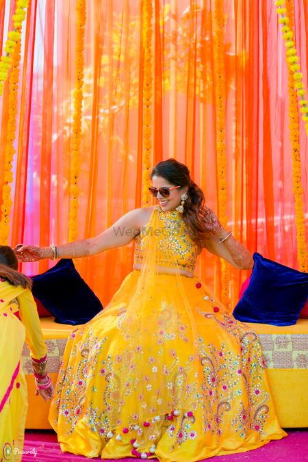 Bride donning a bright yellow and pink lehenga
