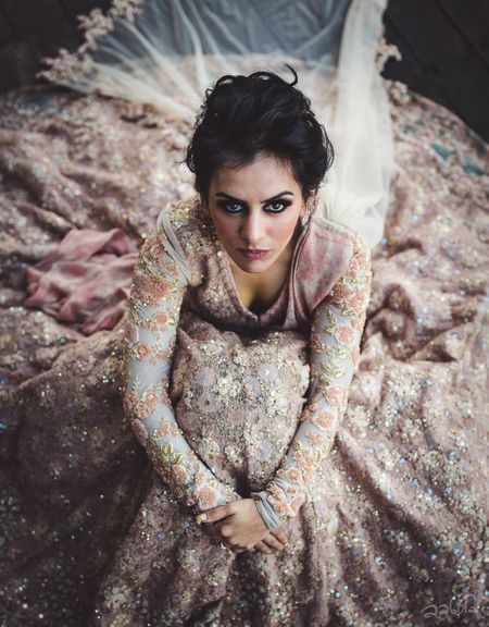 Stunning bridal portrait with bride donning a pink and grey lehenga with heavy work 