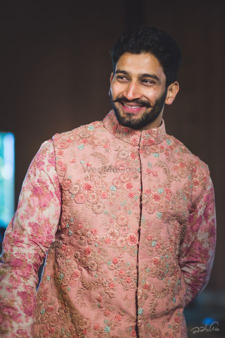 Stunning pink kurta with a floral work jacket on it for the groom on wedding day
