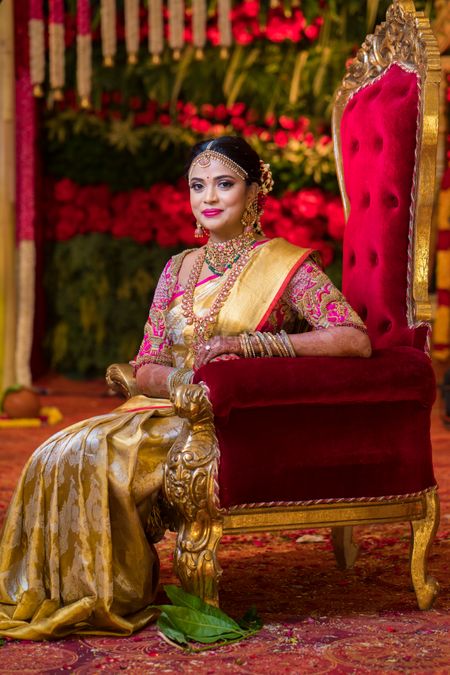 Photo of Bride wearing a gold saree with a bottle green blouse.