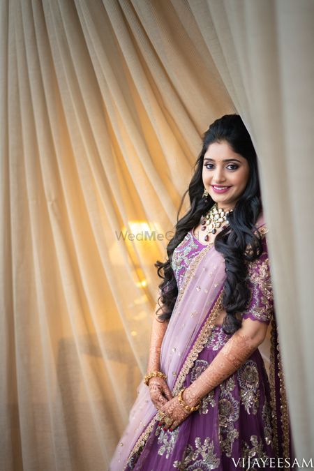 Sangeet bridal look with open hair and purple lehenga 