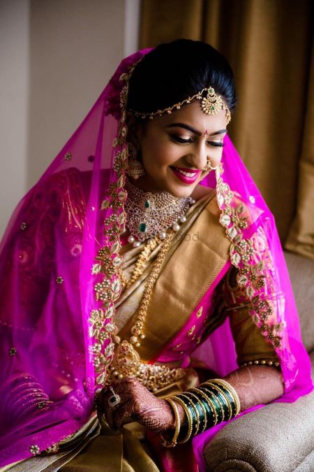 South Indian bride in gold saree with pink dupatta 