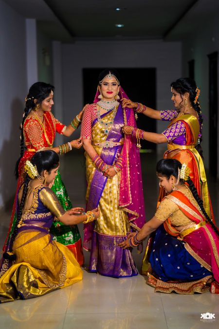 Bridesmaids helping south indian bride get ready 