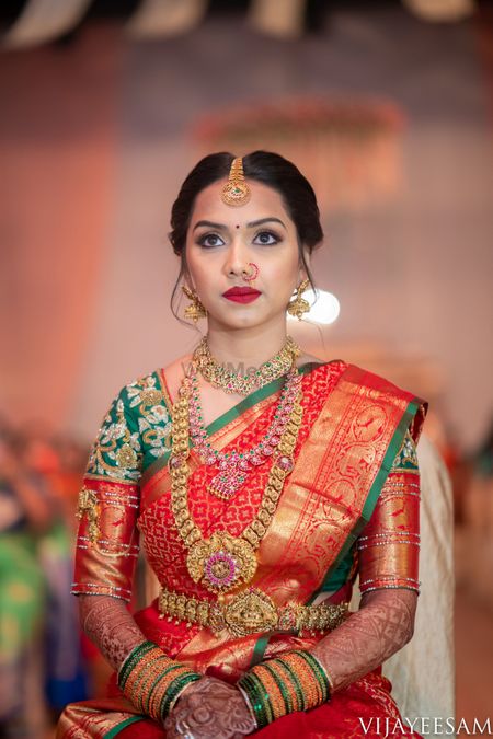 Photo of South Indian bridal jewellery with orange and green saree