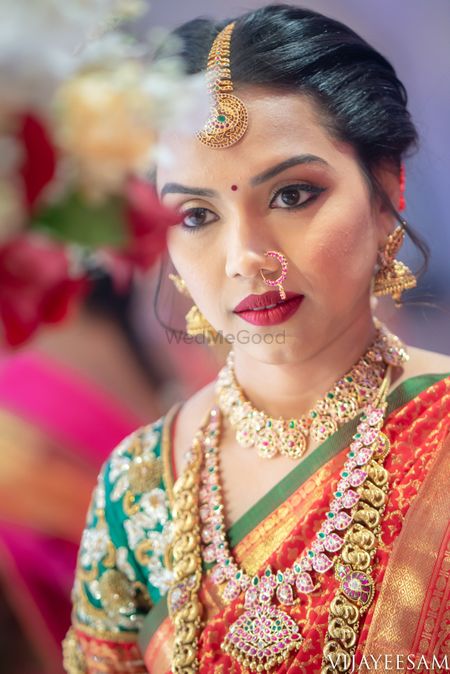 Layered south indian bridal jewellery with orange and green saree