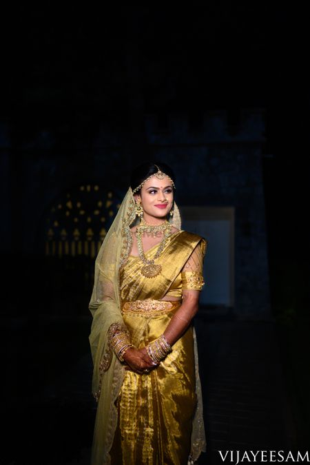 Smiling south indian bride in a gold saree