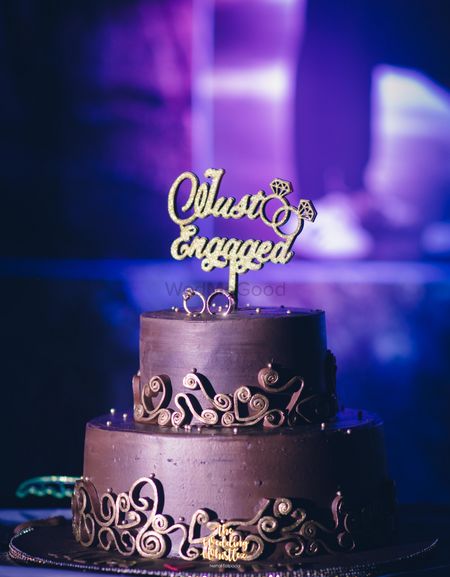 Photo of Brown wedding cake with just engaged topper