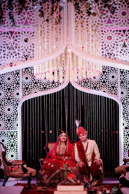 Photo of A couple pose during their wedding at a uniquely done mandap