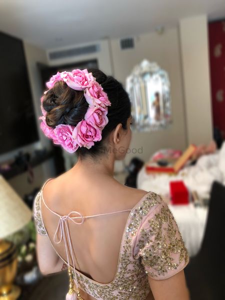Photo of Bridal bun with pink roses on the edge